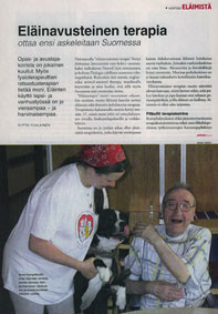 Suomalainen terapiakoira pitbulli ja koulutettu terapiakoira-handleri, ilahtuneen asiakkaan luona. Dialogi-lehden aukeama.