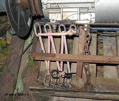 Petojahti-laite. Ylh&auml;&auml;ll&auml; hopean v&auml;rinen s&auml;hk&ouml;moottori, joka on kiinnitetty metalliseen keinuvaan runkoon.